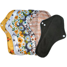 Load image into Gallery viewer, 7 x large reusable sanitary pads in different designs including; floral, birds, daisies, rainbows plus one facing the other way to show the black bamboo absorbent layer.
