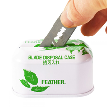 Load image into Gallery viewer, Feather used razor blade bank for used safety razor blades, sustainable shaving. Hand putting used razor into the bank
