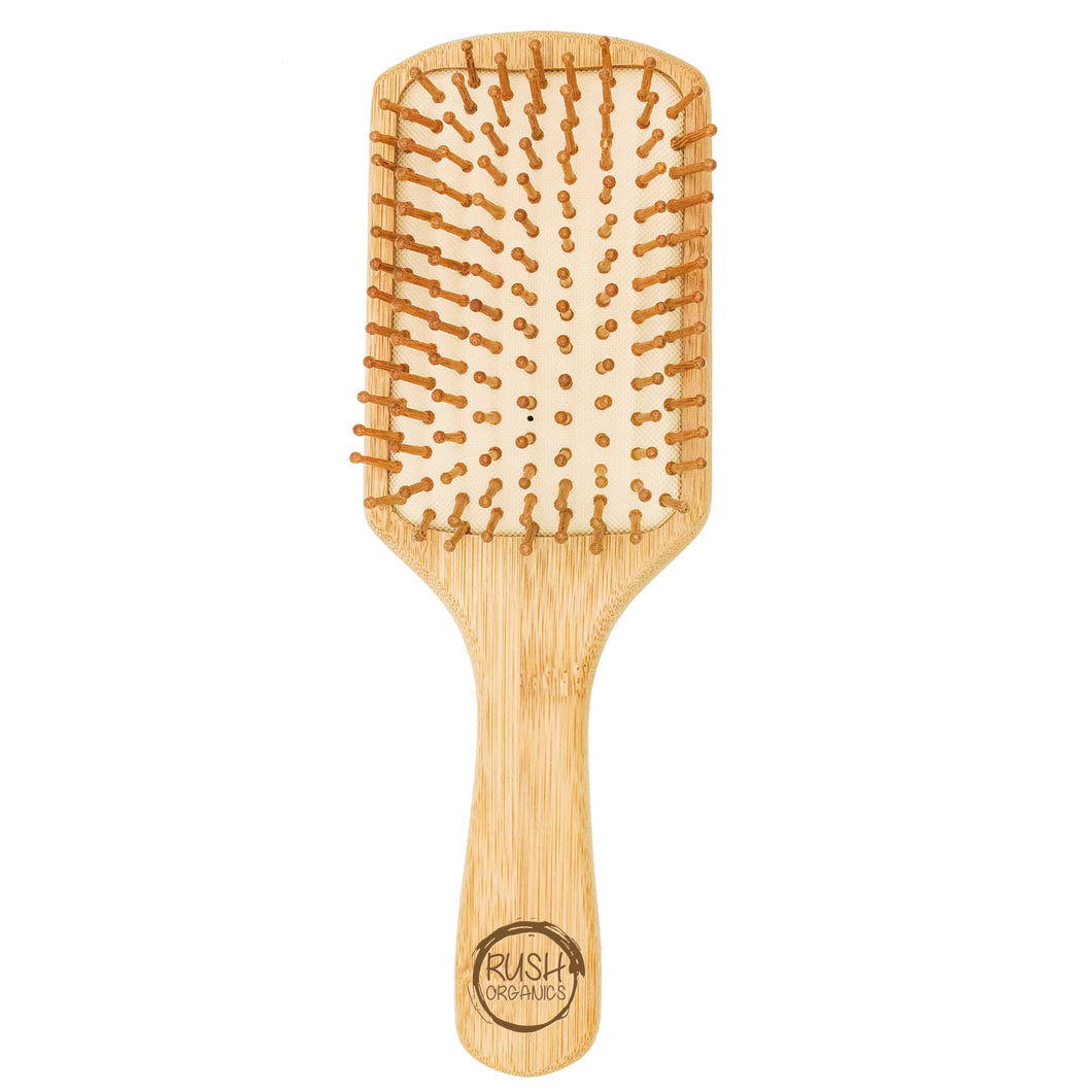 bamboo square paddle hair brush with natural rubber. rush organics logo at the bottom on the handle.